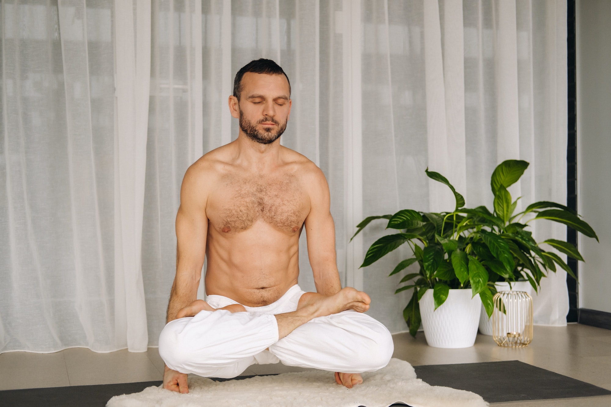 a man with a bare torso does yoga in a fitness room. the concept of a healthy lifestyle