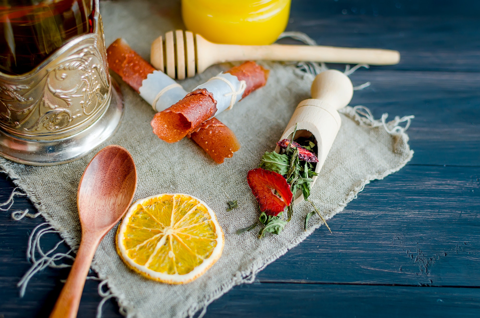 green tea leaves with strawberry in a wooden spoon