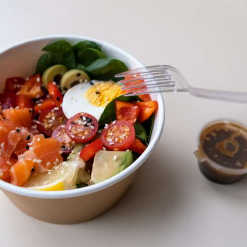 Takeaway poke bowl in recycled kraft paper packaging. Healthy Trendy Fitness food.